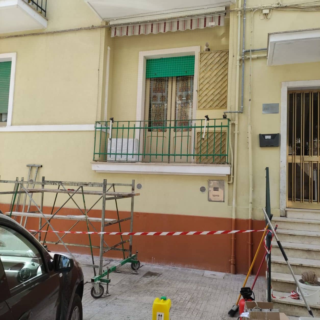 Edificio residenziale con i balconi ancora aperti e il ponteggio montato, prima dell’installazione della rete