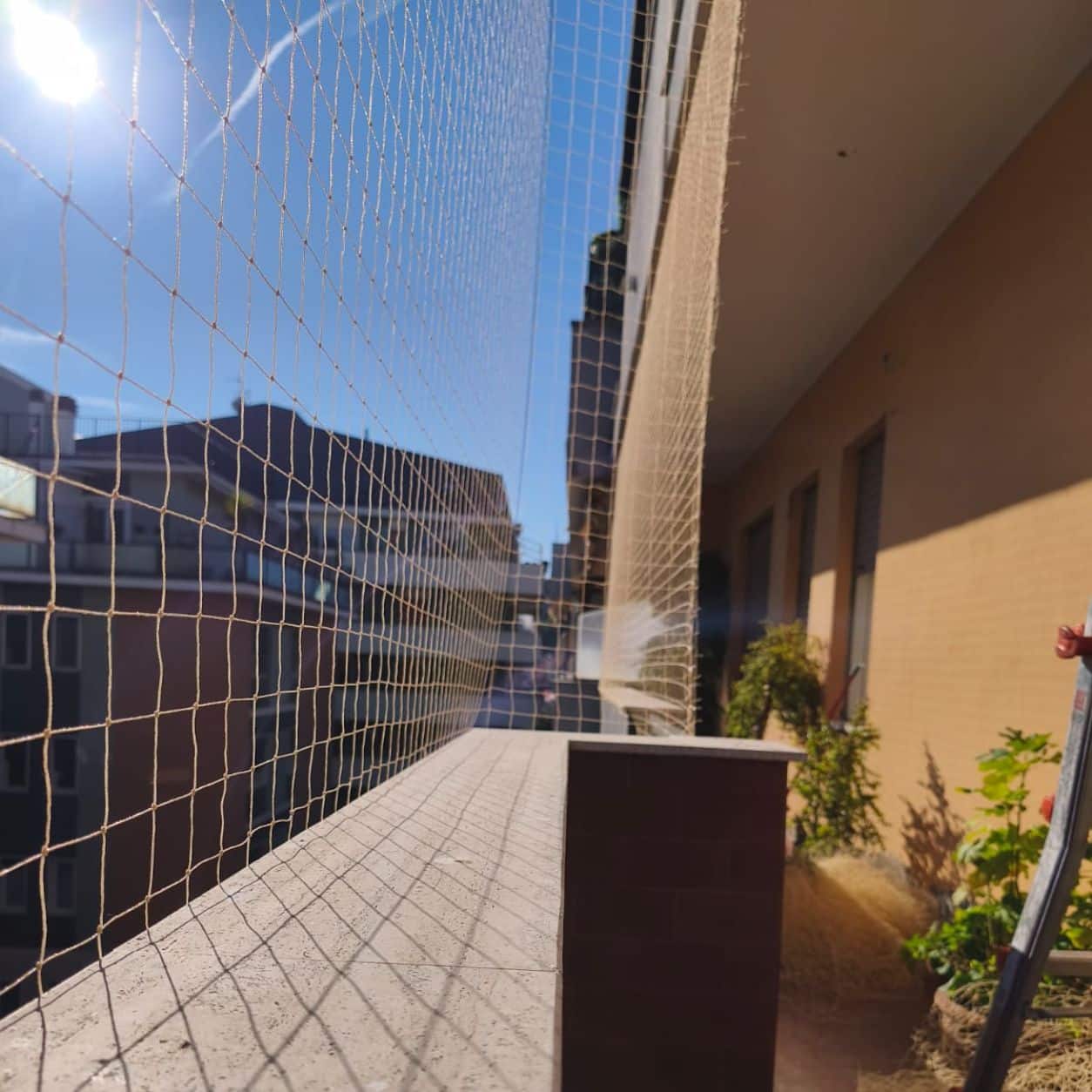 Terrazzo condominiale con rete tesa sopra il parapetto e il piano di calpestio pulito