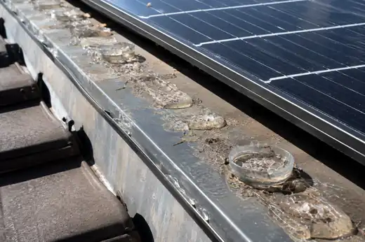 Cordoli di gel repellente ormai secchi e crepati lungo il profilo in alluminio di un pannello fotovoltaico