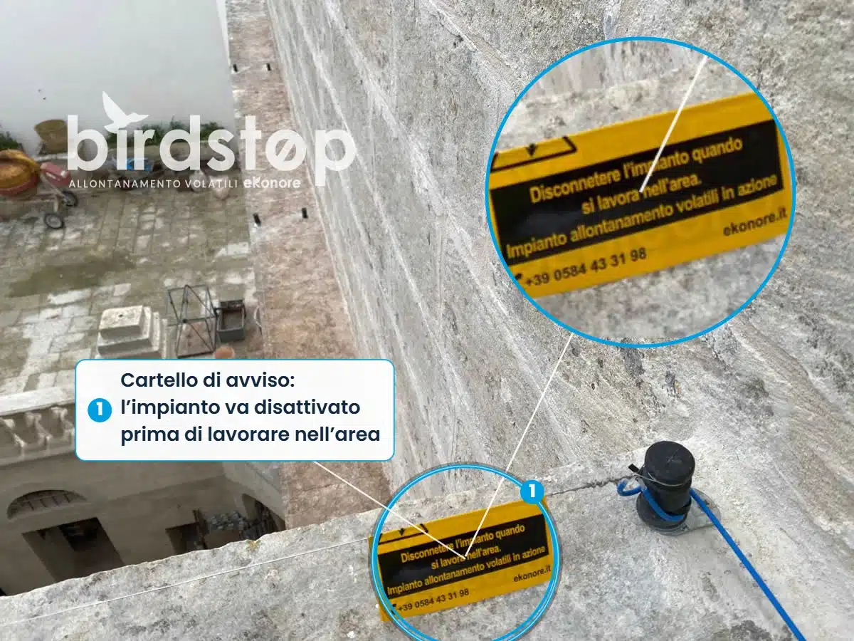 Infografica: il cartello di avviso dell’impianto di allontanamento volatili sul palazzo storico di Minervino di Lecce, con l’indicazione di disattivare l’impianto prima di lavorare nell’area