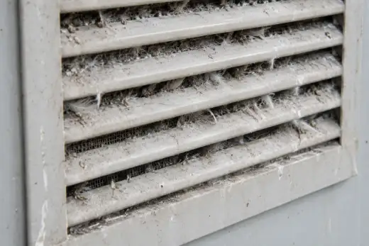 Griglia di ventilazione di un armadio tecnico ostruita da piume e detriti