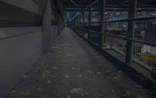 Camminamento metallico di servizio in un capannone industriale con il piano di calpestio sporco di escrementi di piccione