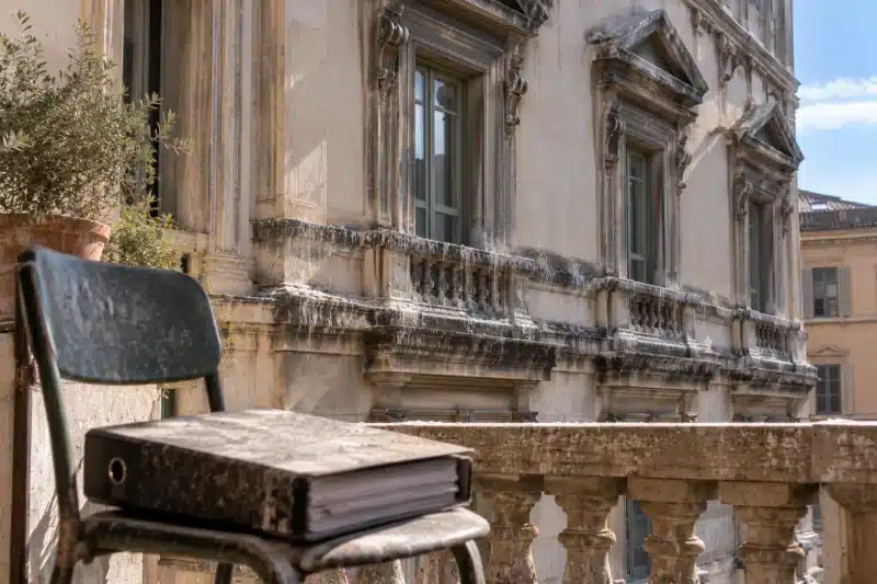 Faldone chiuso appoggiato su una sedia sul balcone di un palazzo storico