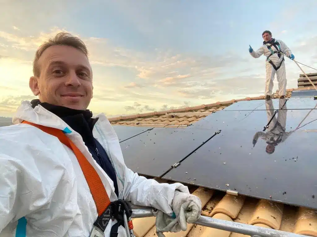 Tecnici Ekonore con tuta e imbracatura al lavoro su un impianto fotovoltaico sul tetto